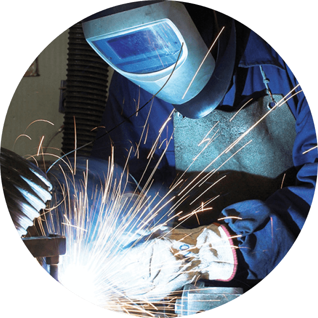 Welder with protective helmet on, drilling with sparks flying